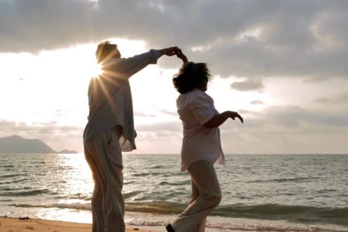 Vacations : Senior couple dancing at beach on sunny day ,Senior couple relaxing by the sea.Senior Holidays.